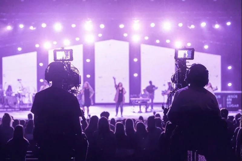Multiple camera operators recording stage performances and audience reactions during a live concert in Kenya.