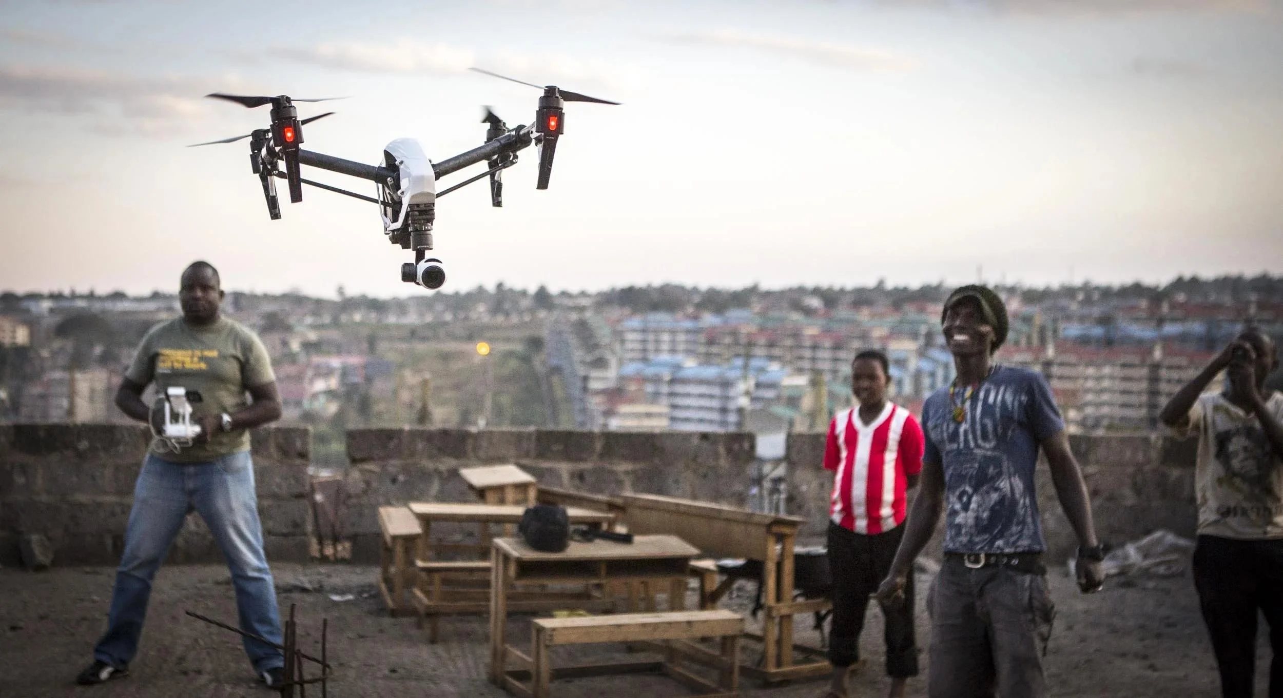 Production crew scouting a filming location and operating a drone for a commercial shoot in Kenya.