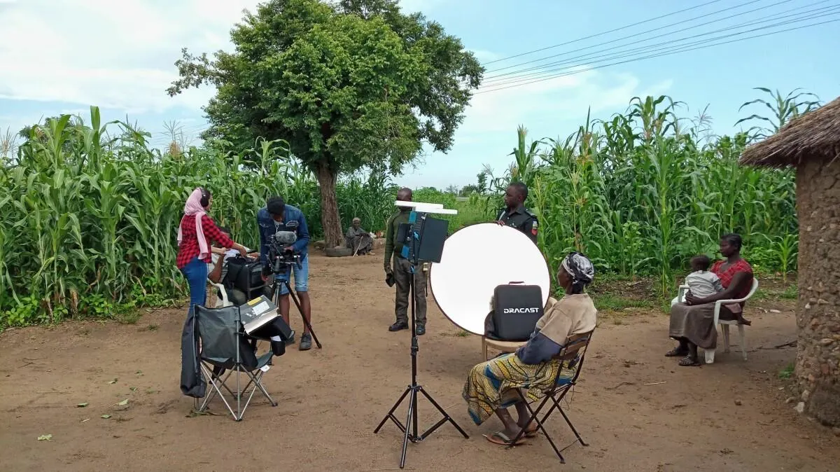 Small documentary film crew using natural light while interviewing community members in rural Kenya.
