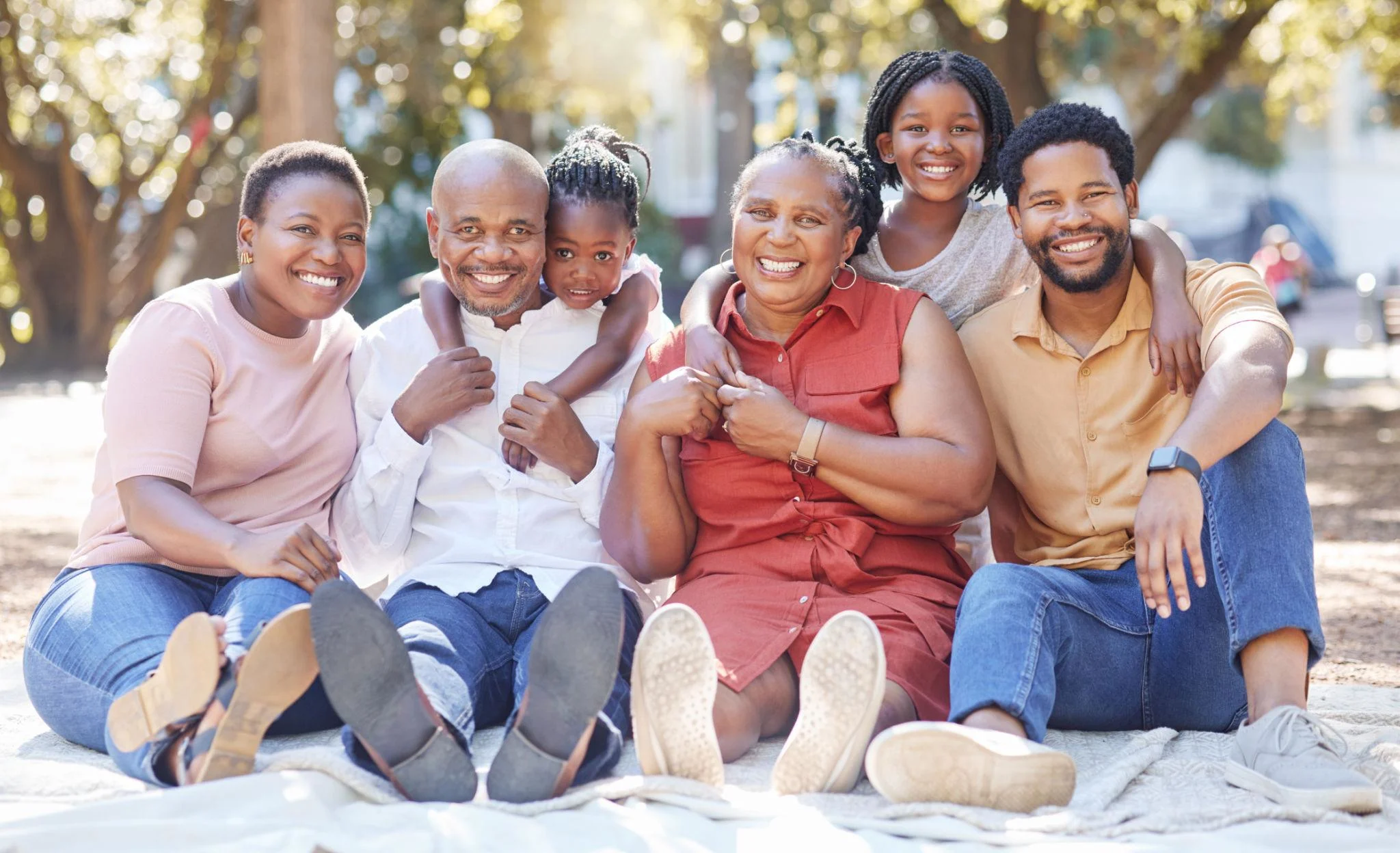 Large multi-generational family portrait in Kenya with grandparents, parents and children outdoors