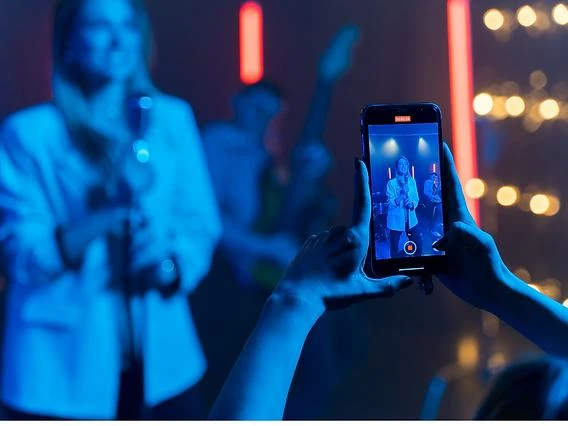 Camera operator recording a live concert vertically for TikTok, Instagram Reels, and mobile social media campaigns